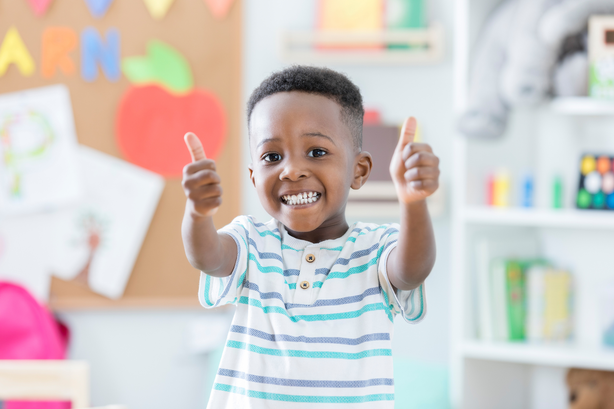 A boy at school giving a thumbs up