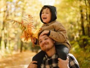 Child with autism and his dad on a fall nature walk