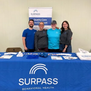 Smiling coworkers at tradeshow booth.