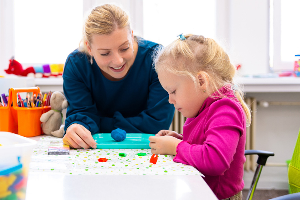 Happy mother and daughter playing a game at a table.