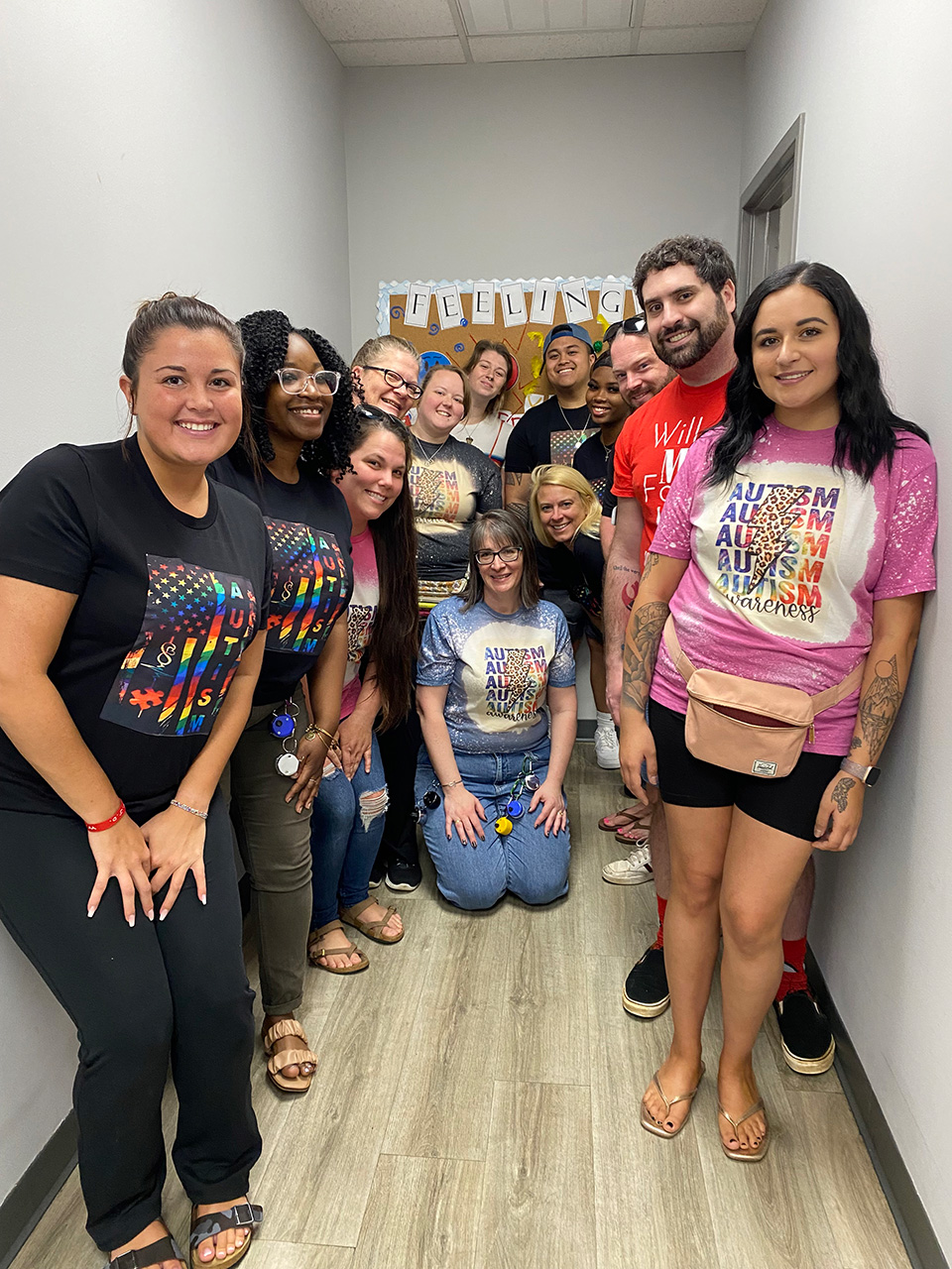 Several smiling coworkers in hallway.