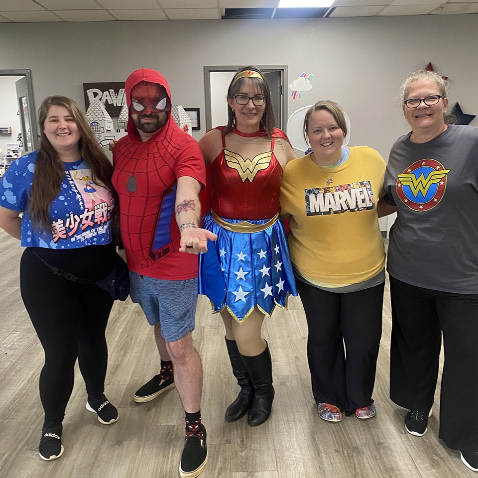 Coworkers wearing super hero costumes.