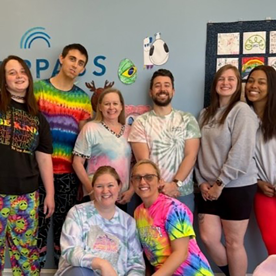 Coworkers wearing tie-dye shirts.