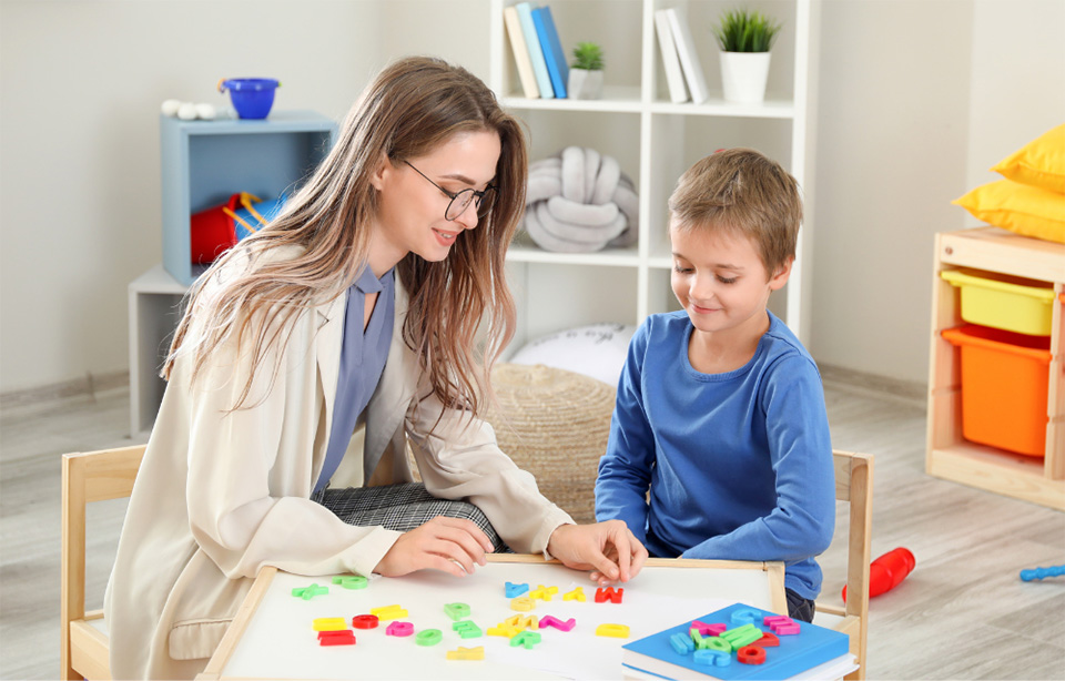 Mom and child play with letters on table.