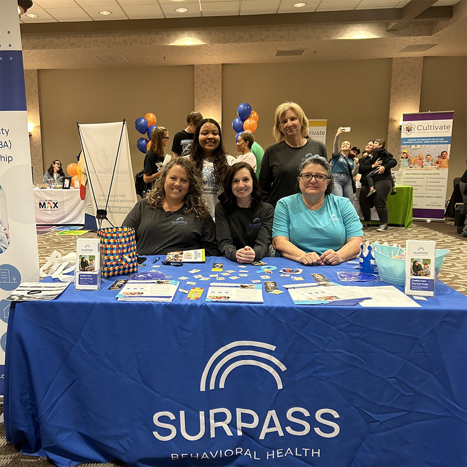 Coworkers at trade show booth for Suprass Behavioral Health.