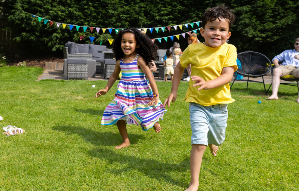 Happy kids running in backyard party.