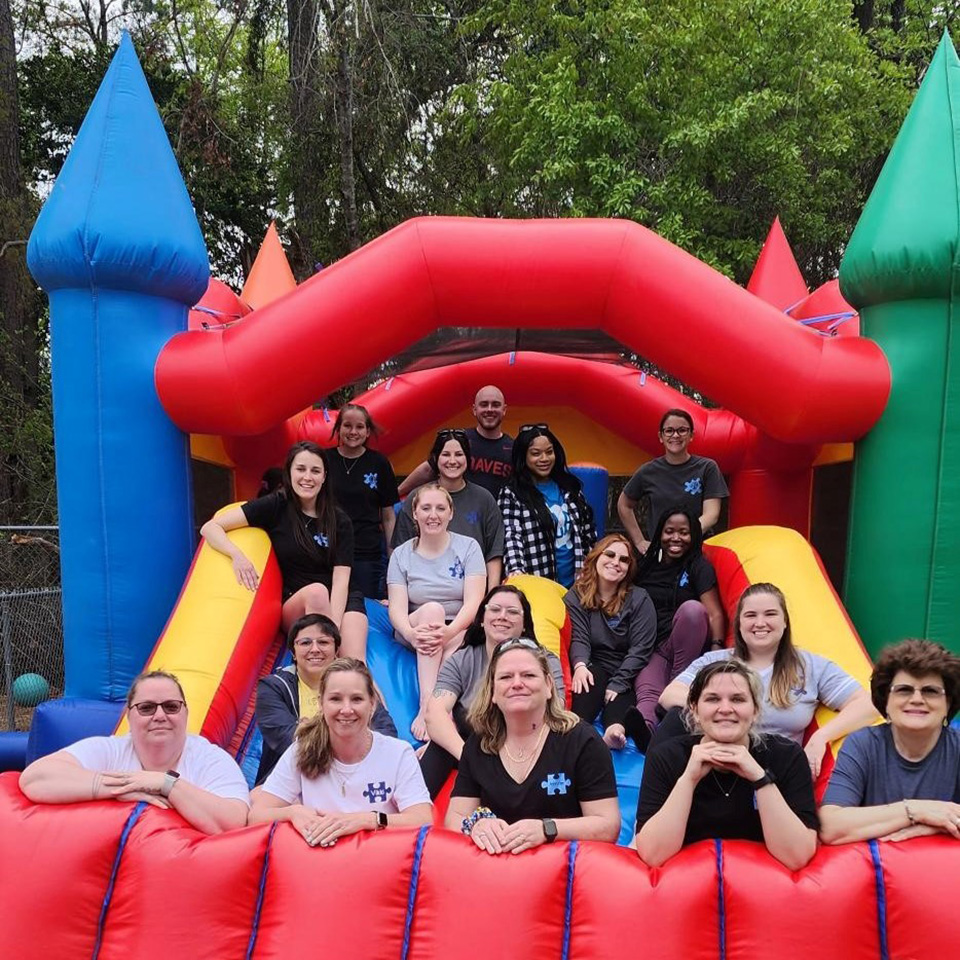 Coworkers posing in group inside bounce house.