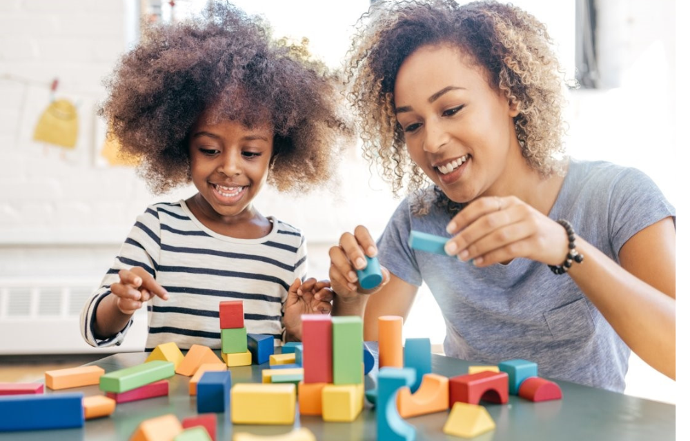 Child and mom playing with colorful blocks.