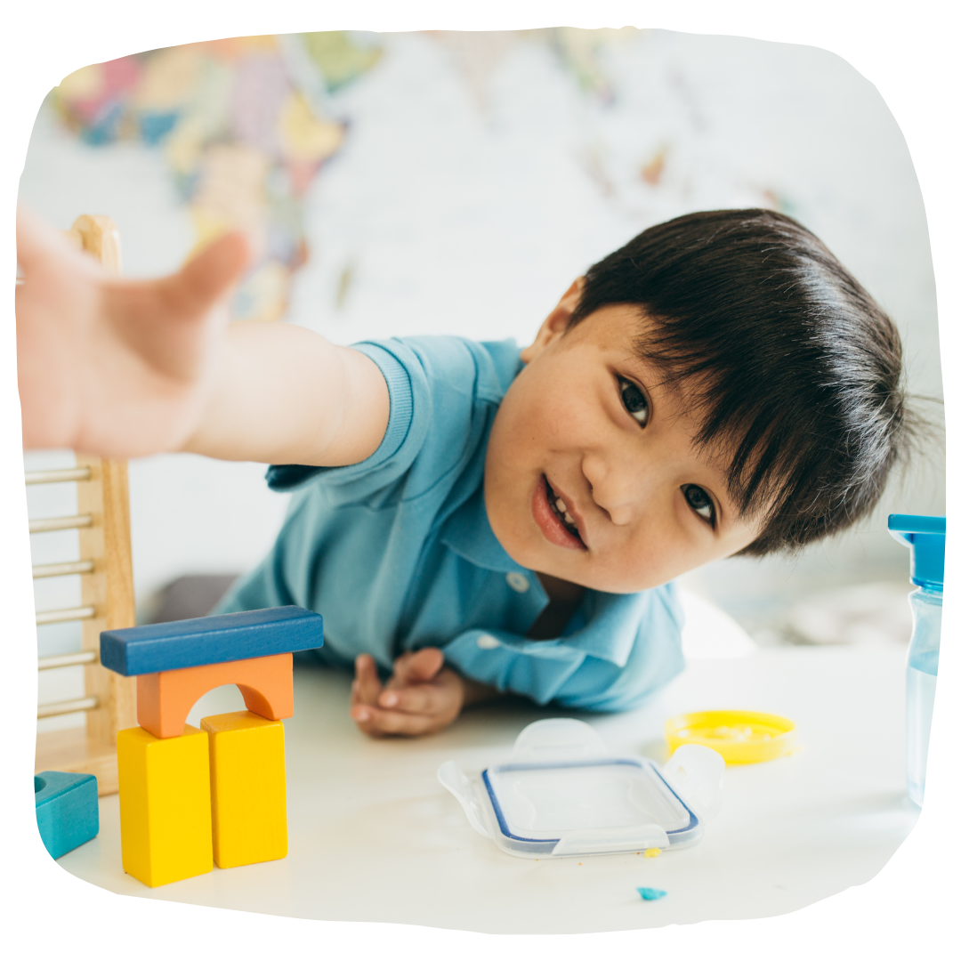 Little kid playing at a table.