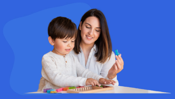 Woman playing with child at a table.