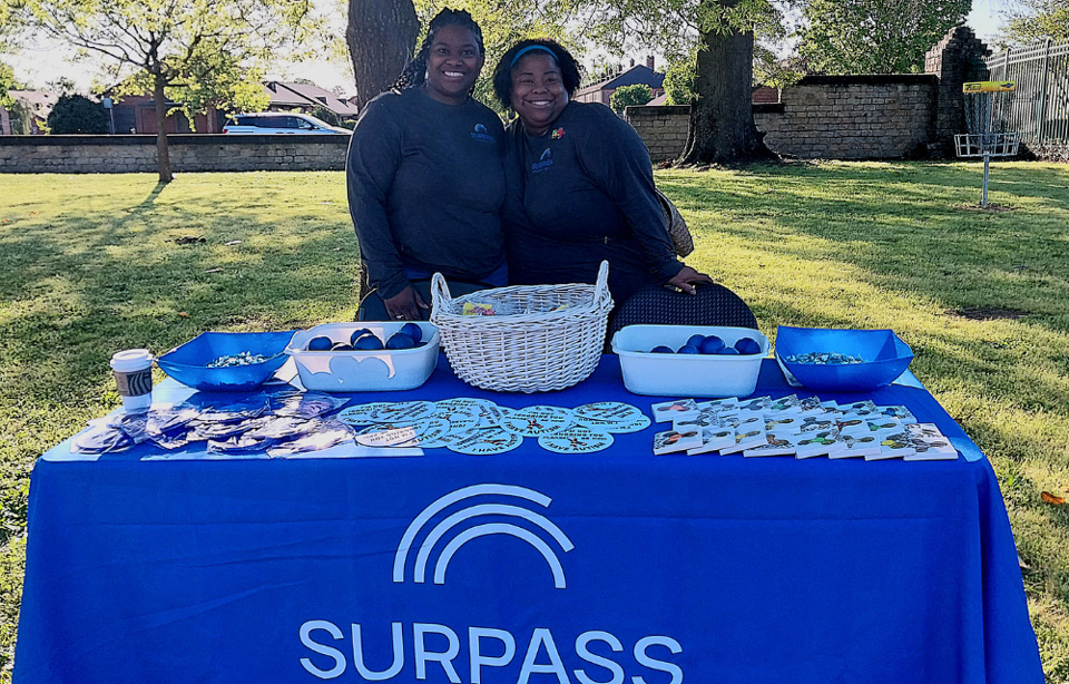 Employees at company booth at outdoor event.
