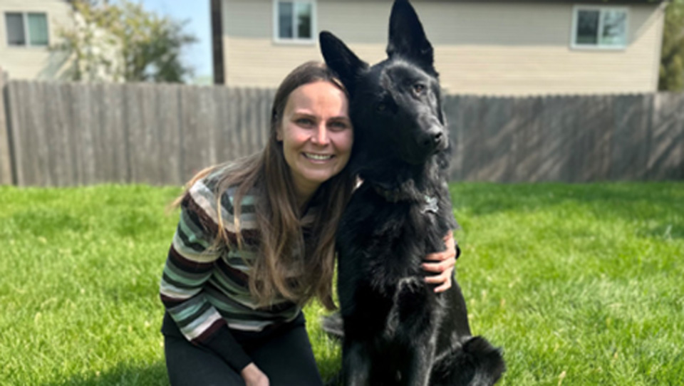 Woman with dog in backyard.