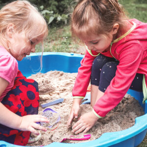 Kids playing in sandbox.