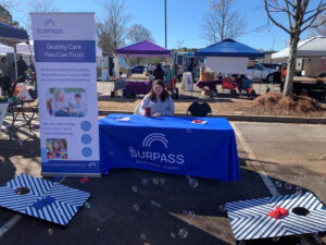 Employee at company booth at outdoor event.